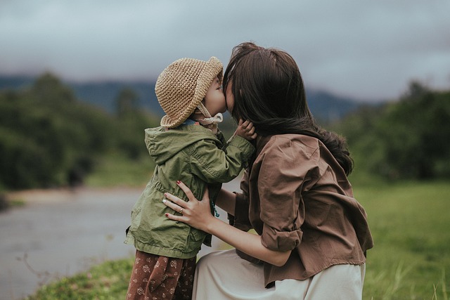 mother hugging and kissing child outdoors showing family connection and balance